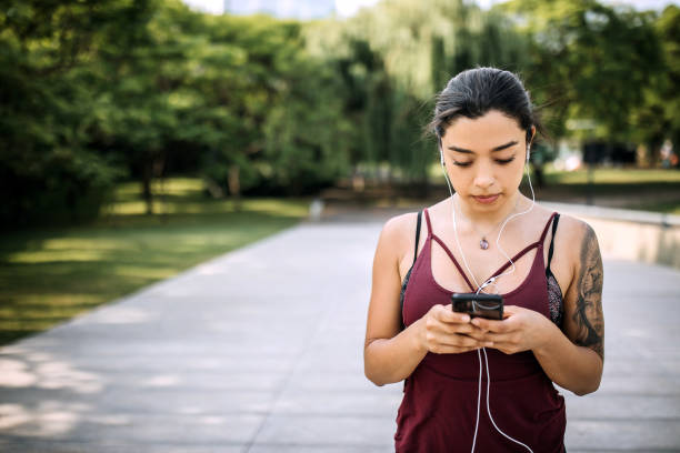 istock Woman preparing right music for running while taking a break 1207748150