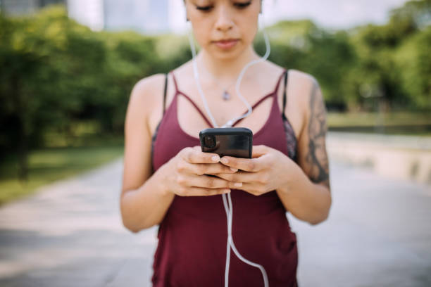 istock Woman preparing right music for running while taking a break 1207748294