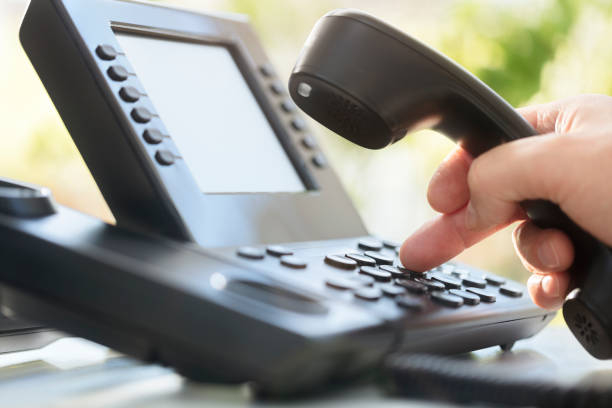 dialing clavier téléphonique dans le bureau - sonner photos et images de collection