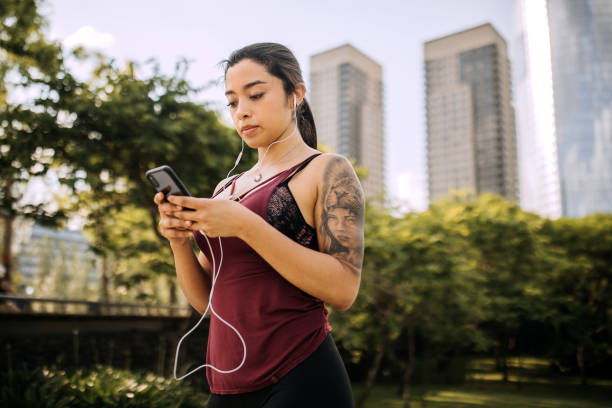 istock Woman preparing right music for running while taking a break 1207750156