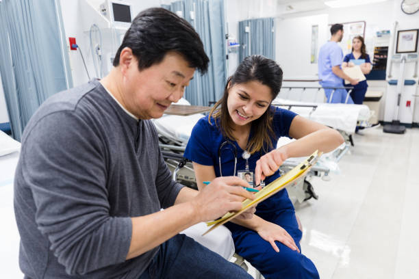 istock Friendly nurse helps senior man with emergency room documents 1207750758