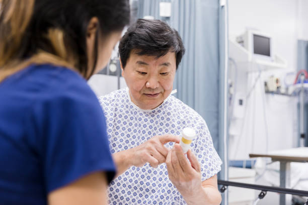istock Senior male patient asks unrecognizable nurse question about medication 1207750786