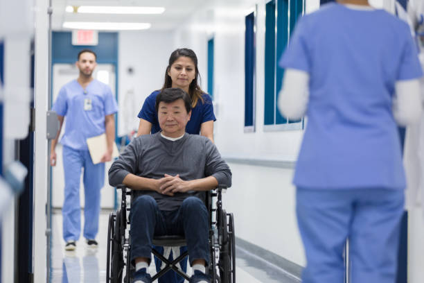 istock Nurse pushes patient in wheelchair 1207751569