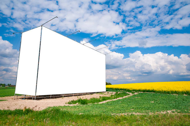 bandeira branca em branco/outdoor no prado perto de um campo de colza florescente. dia ensolarado com céu azul e algumas nuvens brancas. - nature street rural scene outdoors - fotografias e filmes do acervo