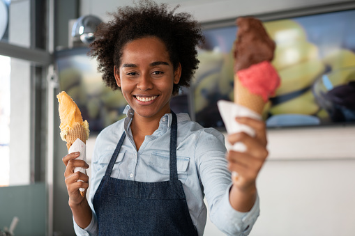 Woman smiling to the camera and holding an ice cream