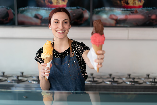 Woman smiling to the camera and holding an ice cream