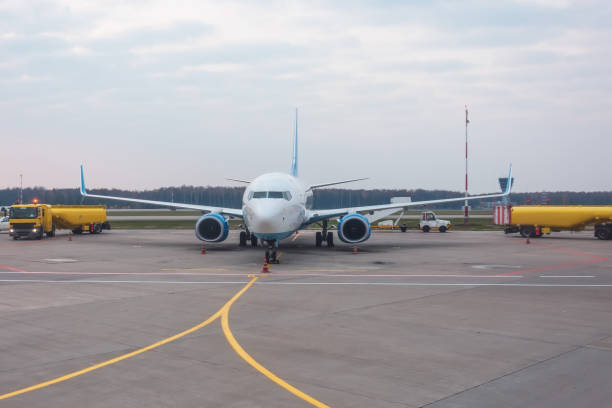 istock Trucks refueling trucks with trailers next to a passenger airplane. 1207755112