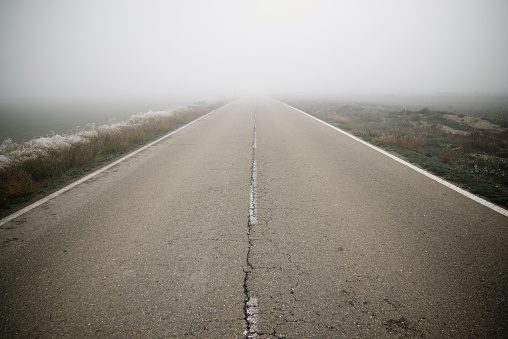 Straight road that goes towards the fog in Zaragoza Province, Aragon in Spain.