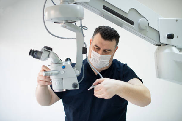 technician repairing an operating microscope - equipamento médico imagens e fotografias de stock
