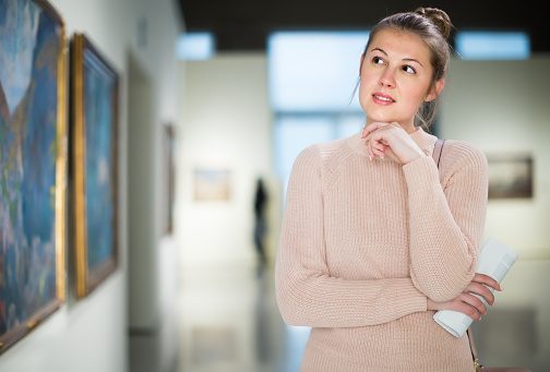 Portrait of woman looking at pictures and amaze in museum