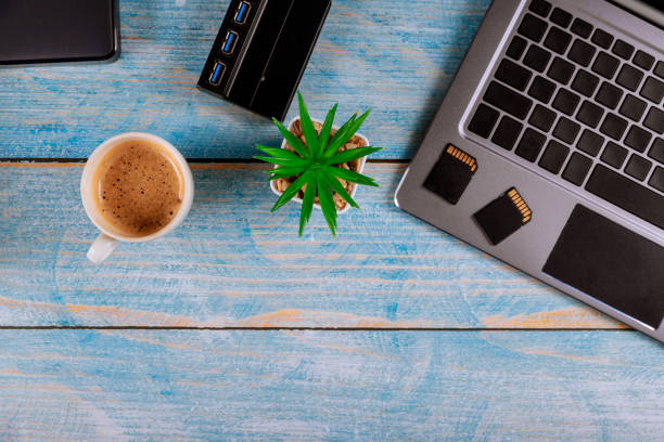istock Office working photographers desk top view with laptop with external hard drive disk, SD card glasses and coffee 1207774524