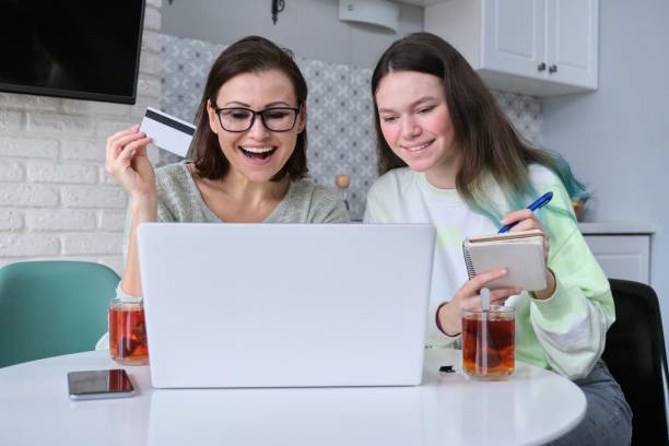 어머니와 딸 을 사용하여 노트북 신용 카드 과 하기 온라인 쇼핑 - paying children only retail childhood 뉴스 사진 이미지