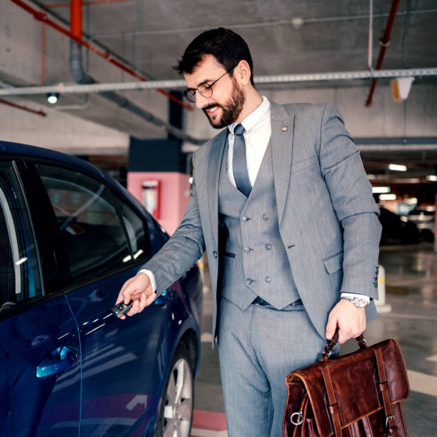 istock Businessman in the garage unlocking his car. 1207784318