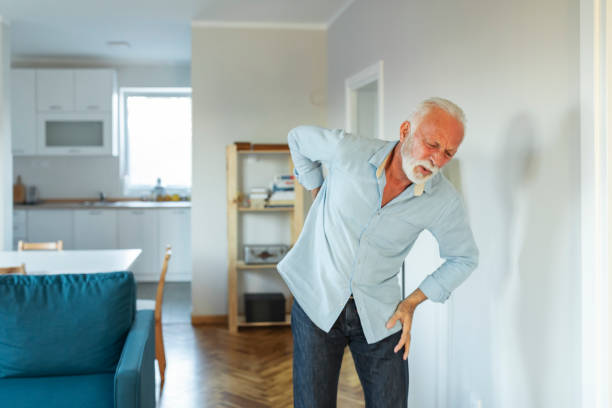 背中に痛みを持つ毎日の部屋の先輩男性 - arthritis osteoporosis pain backache ストックフォトと画像