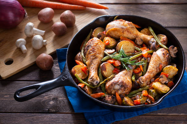 Skillet Chicken And Vegetables Chicken with Potatoes, Green Beans, Brussels Sprouts, Carrots and Mushrooms, Roasted in a Cast Iron Skillet skillet cooking pan photos stock pictures, royalty-free photos & images