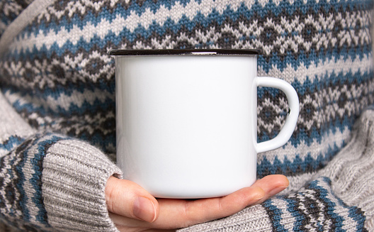 Enamel Mug with black edge line Mock-up. Girl holds white old-tin campfire cup in her hands.