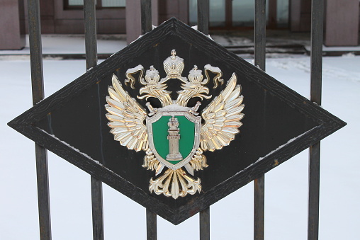 Emblem of the prosecutor's office, state symbols, the figure of a double-headed eagle on a metal black gate. Stock photo wit empty space for text and design.