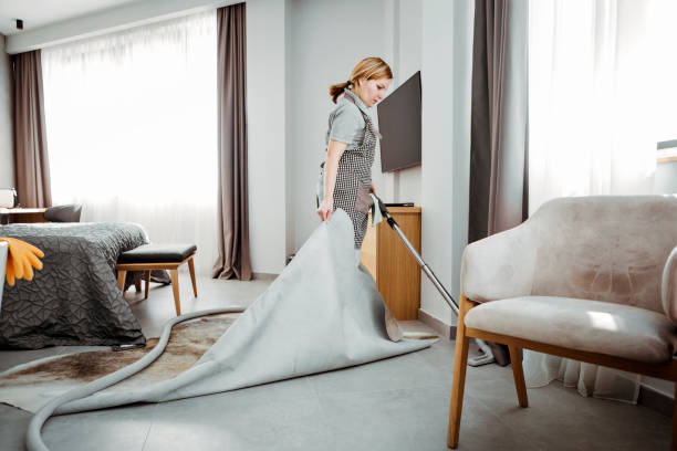 istock Maid vacuuming hotel room under carpet 1207800463