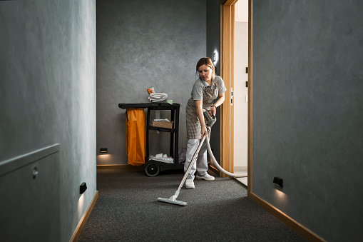 maid vacuuming hotel room