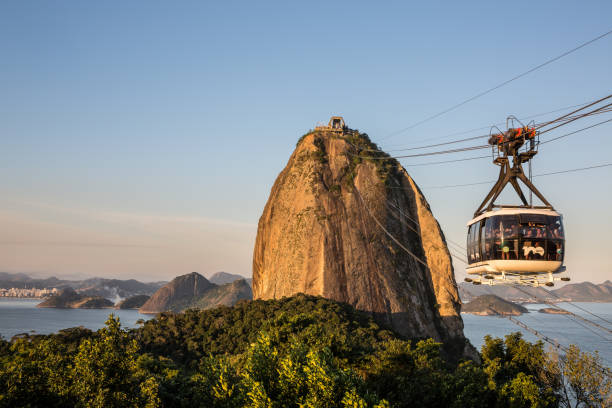 teleférico en la montaña pan de azúcar durante la puesta de sol en río de janeiro, brasil - sugarloaf fotografías e imágenes de stock