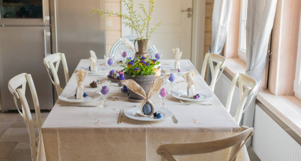 istock Easter festive spring table setting decoration, bunny ears shaped napkins, dyed eggs, cakes, flowers, selective focus 1207807167