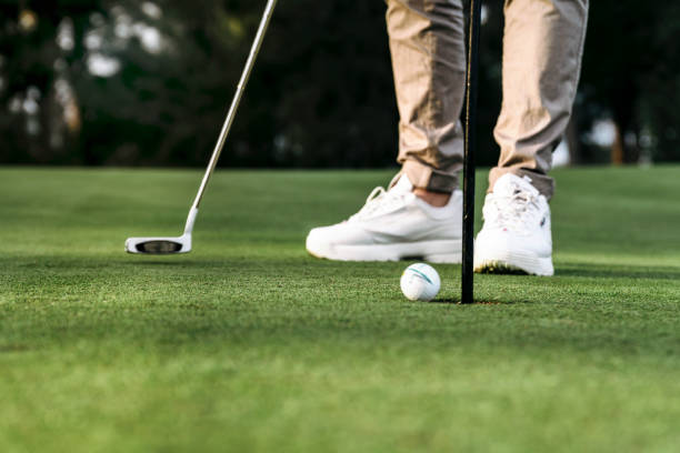 joven irreconocible jugando al golf como actividad de fin de semana. - golf power golf course challenge fotografías e imágenes de stock