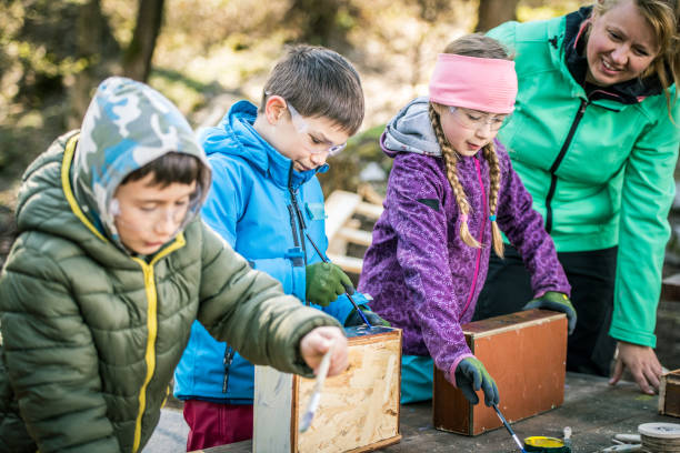 istock Kids painting wood with paintbrushes 1207817097