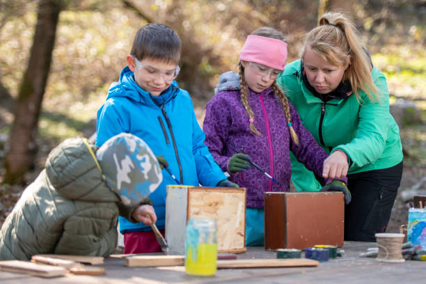 istock Kids painting wood with paintbrushes 1207817114