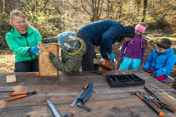 istock Teachers and children doing carpentry at an outdoor workbench 1207817117