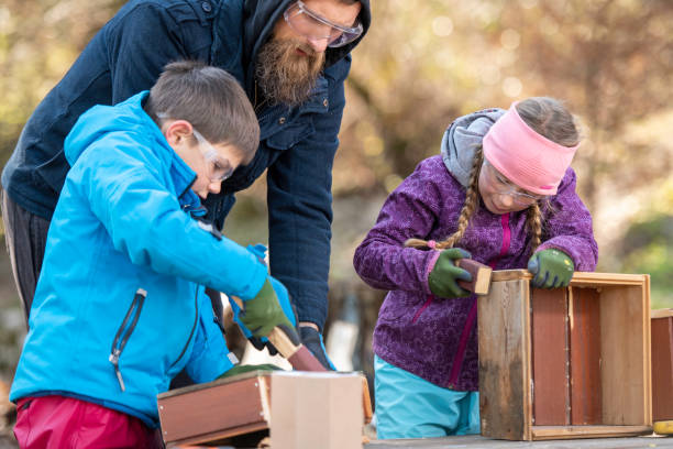 istock Kids sanding wooden boxes with sandpaper 1207817122