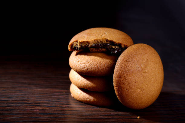 istock Biscuits filled with chocolate cream. Chocolate cream cookies. brown chocolate biscuits with cream filling on black background. 1207822688
