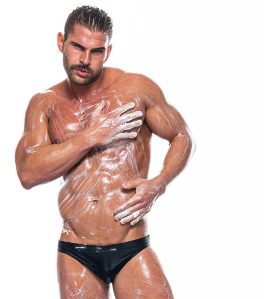 Caucasian male standing in front of white background wearing racing briefs Waist up of aged 30-39 years old with short hair caucasian male standing in front of white background wearing racing briefs who is shirtless who is cleaning shower men falling water soap sud stock pictures, royalty-free photos & images