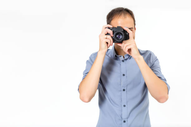 istock Bend young man taking photo with digital camera side view. isolated over white background. 1207829790
