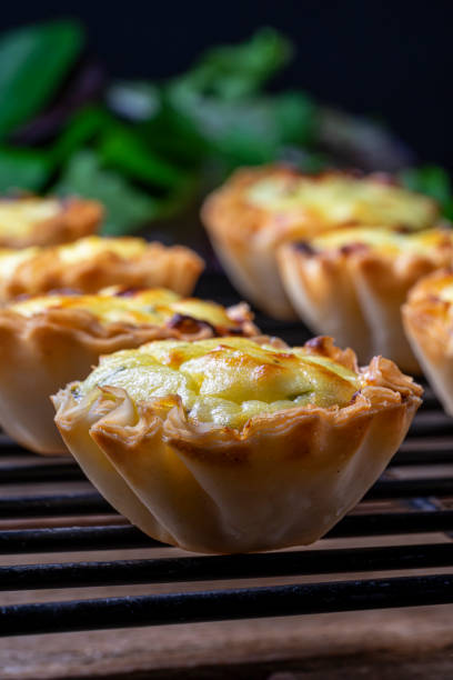istock Filo pastry cups with cheese (tyropita) cooling on a black wire rack. 1207832458