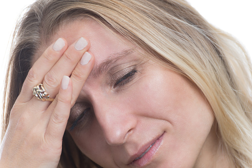 Portrait of a woman having a migraine, headache on a white background