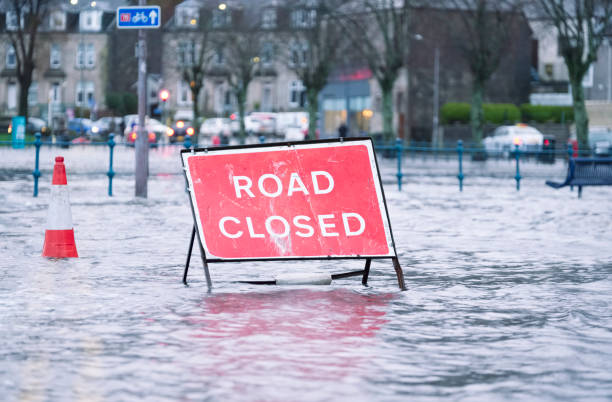 señal cerrada de la inundación de la carretera bajo aguas profundas durante el mal tiempo de tormenta de lluvia extrema en el reino unido - river road sign road sign fotografías e imágenes de stock