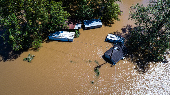 Dirty brown water flooded homes up to the rooftops Aerial drone views high above Flooding caused by Climate Change , homes and suburb destroyed by deadly flash flooding and Hurricane intense rain storm
