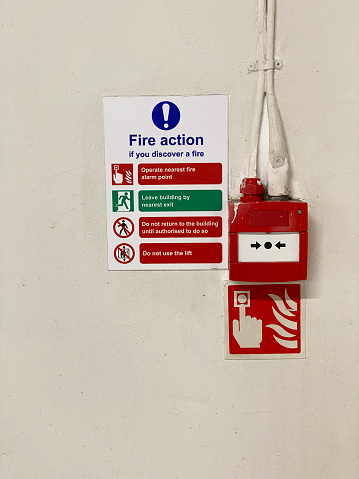 Señal del plan de acción contra incendios y punto de alarma contra incendios manual en el lugar de trabajo público photo