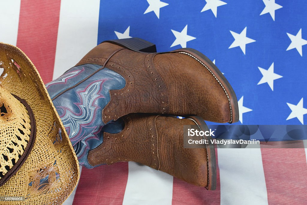 Cowboy boot and straw hat Cowboy boot and straw hat on American flag background American Culture Stock Photo