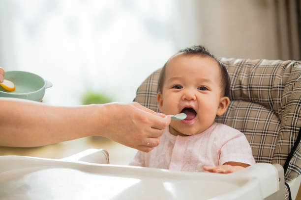 Mãe para alimentar o arroz bebê - foto de acervo