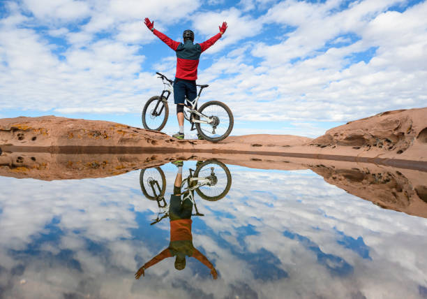 istock Mountain Biker Arms Raised Reflection In Utah 1207855129