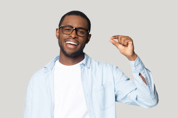 istock Happy excited millennial african american guy showing small prices gesture. 1207856404