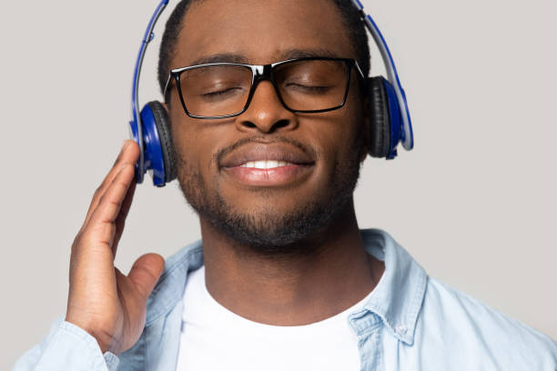 istock Smiling young african american man enjoying favorite music tracks. 1207856421