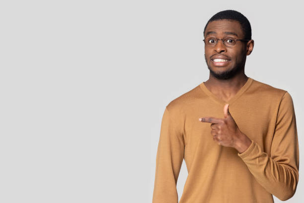 istock Worried african american guy, pointing aside at blank copy space. 1207856425