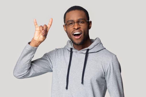 istock Playful excited young african american guy singing, showing horns sign. 1207856437