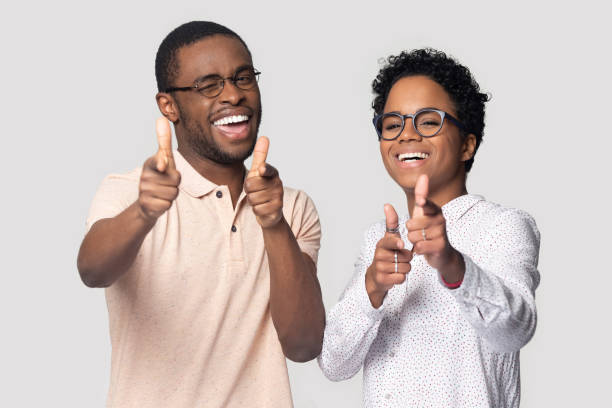 istock Happy joyful african american family couple pointing at camera. 1207856445