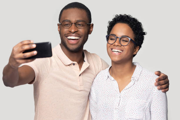istock Happy african american guy embracing smiling woman, making selfie. 1207856458