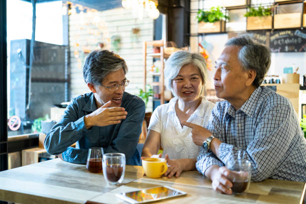 istock Asian family sitting in cafe and talking 1207856599