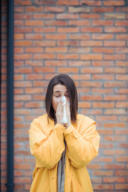 istock Sick young woman blowing her nose 1207856771
