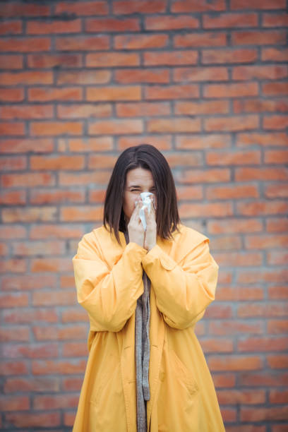 istock Sick young woman blowing her nose 1207856773